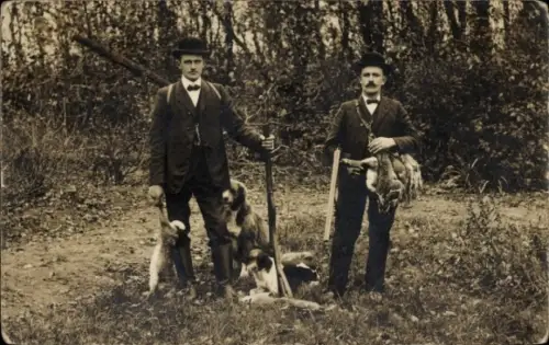 Foto Ak zwei Jäger mit Beute und ihren Jagdhunden
