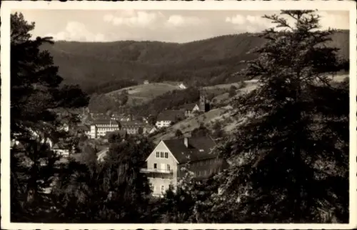 Ak Alpirsbach im Schwarzwald, Landschaft mit Hügeln, Bäumen, Häusern, Kirche, Schwarz-Weiß-Foto