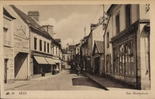 Ak Sées Orne, Straße Rue Montjaloux,  Häuser, Radfahrer