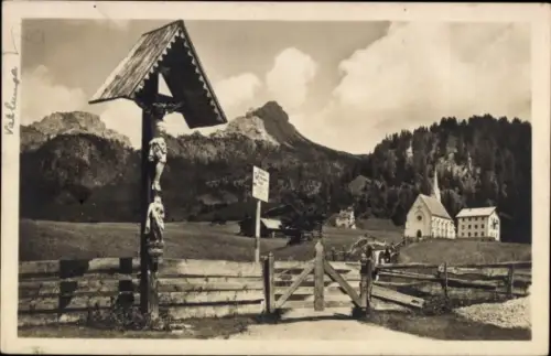 Ak Gröden Selva di Valgardena Südtirol, Landschaft mit Bergkulisse, Holzskulpturen, Kirche, Zaun