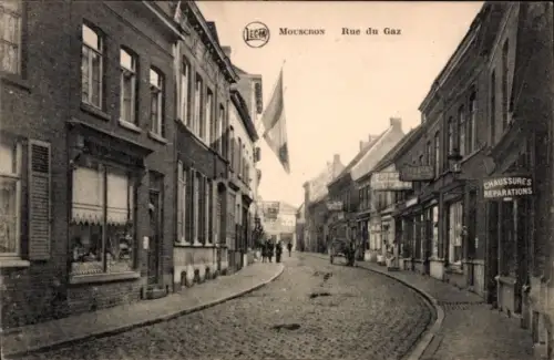 Ak Mouscron Wallonien Hennegau, Straße mit Häusern, Flagge, Schildern, Menschen