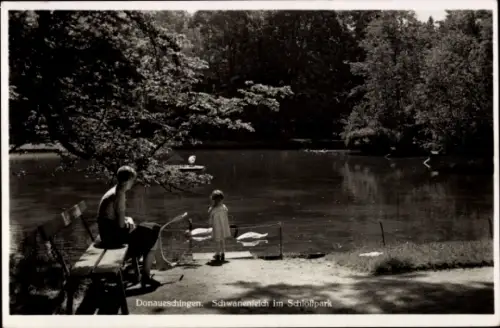 Ak Donaueschingen im Schwarzwald, Mann auf Bank, Kind am Wasser, Schwanenteich, Schlosspark