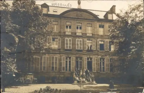 Ak Versailles Yvelines, Vorderansicht eines Gebäudes, Schriftzug 'VERSAILLES', Menschen im Garten