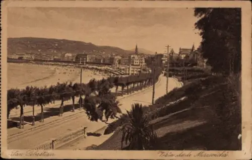 Ak Donostia San Sebastian Baskenland, Blick auf  Strandpromenade, Bäume, Berge im Hintergrund