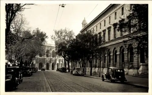 Ak Nîmes Gard, Straße mit Bäumen, Autos, Lycée, Arènes im Hintergrund
