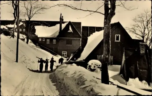 Ak Klingenthal im Vogtland Sachsen, Aschbergstraße, vier Personen mit Skiern 