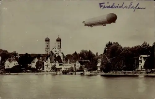 Foto Ak Friedrichshafen am Bodensee, Zeppelin Luftschiff über der Stadt, Kirche, Seeufer