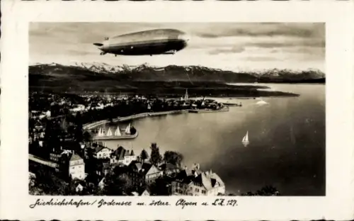 Ak Friedrichshafen am Bodensee, LZ 127 Graf Zeppelin über der Stadt, Panorama mit österr. Alpen