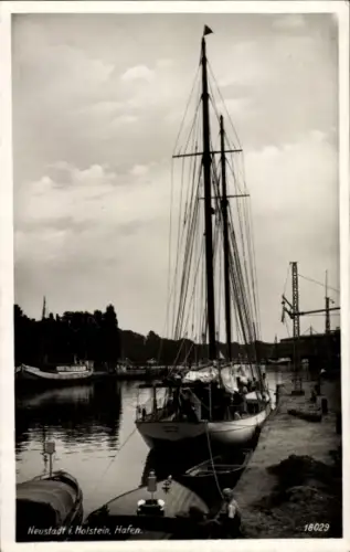 Ak Neustadt in Holstein, Segelboot im Hafen, Mehrere Boote, Kran im Hintergrund, Wasser, Wolken