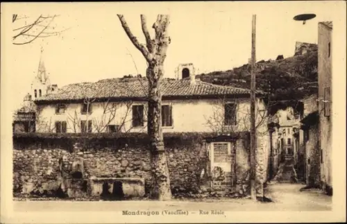 Ak Mondragon Vaucluse, Vorderansicht einer Straße, Gebäude mit großem Baum, Felsen im Hintergrund