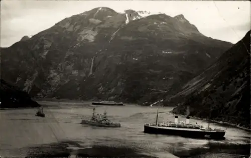 Ak Geiranger Norwegen, Mehrere Schiffe fahren durch einen Fjord, dahinter sind Berge zu sehen.