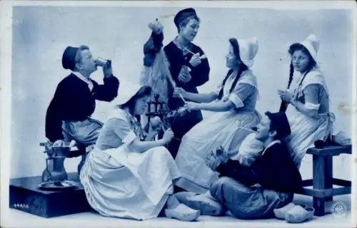 Ak Junge Männer und Frauen in niederländischer Tracht, Spinnrad, Pfeife, Holzschuhe, NPG 444/15
