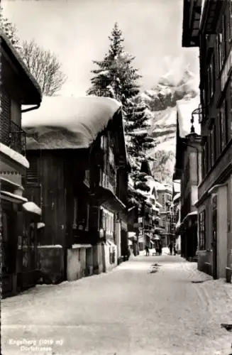 Ak Engelberg Kanton Obwalden Schweiz,  Dorfstrasse, schneebedeckte Straße, Berge im Hintergrund