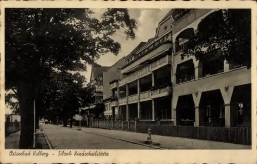 Ak Kołobrzeg Ostseebad Kolberg Pommern, Ostseebad  Siloah Kinderheilstätte, Straße, Bäume