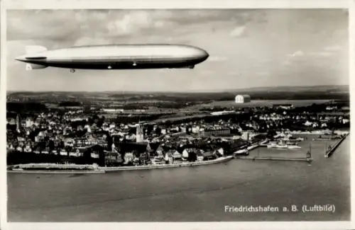 Ak Friedrichshafen am Bodensee, Luftschiff LZ 127 Graf Zeppelin über der Stadt, Fliegeraufnahme