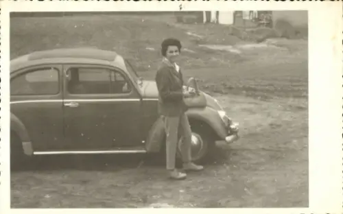 Foto Ak Frau steht neben einem Auto, VW Käfer