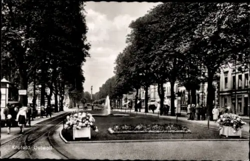 Ak Krefeld am Niederrhein,  Ostwall, Bäume, Blumenbeete, Brunnen, Menschen