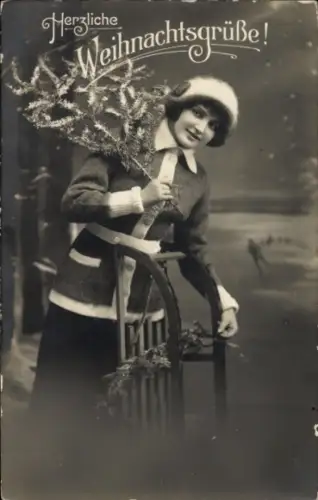 Ak Frohe Weihnachten, Frau mit Schlitten und Tannenzweig