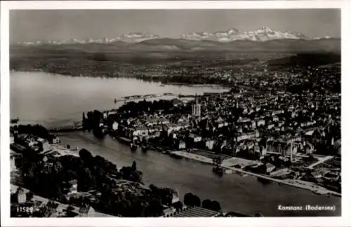 Ak Konstanz am Bodensee, Luftaufnahme von  Bodensee, Berge im Hintergrund, Fluss, Stadtansicht