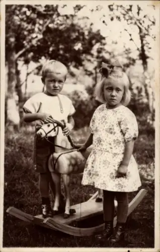 Foto Ak Zwei Kinder auf einem Schaukelpferd