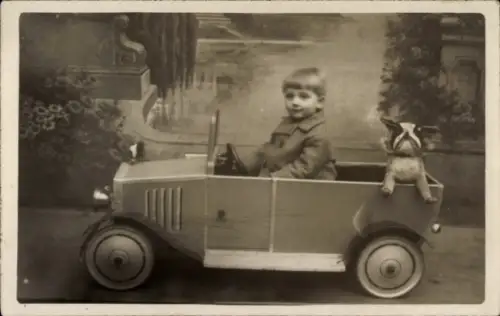 Foto Ak Kleinkind in einem Spielzeugauto, Stoffhund