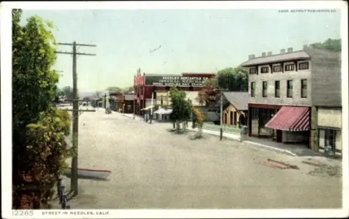 Ak Needles Kalifornien USA, Straße in Needles, Geschäfte, Bäume, Stromleitungen