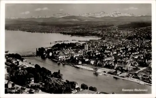 Ak Konstanz am Bodensee, Luftaufnahme von  Bodensee, Berge im Hintergrund, Fluss, Stadtansicht