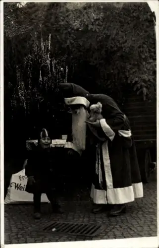 Foto Ak Weihnachtsmann überreicht einem Kind Geschenke