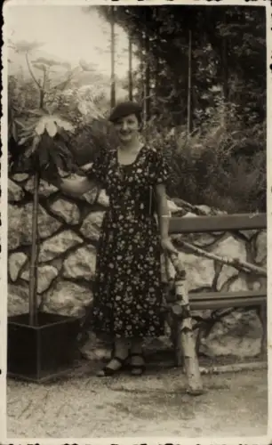 Ak Janské Lázně Johannisbad Region Königgrätz, Frau in Blumenkleid, Hut, neben Pflanze, Steinmaue