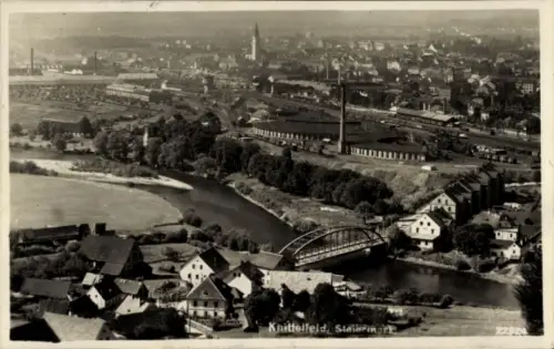 Ak Knittelfeld Steiermark, Luftaufnahme von  Fluss, Brücke, Industrieanlagen