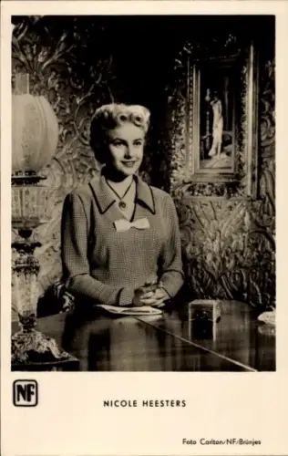 Ak Schauspielerin Nicole Heesters, Portrait, an einem Tisch sitzend