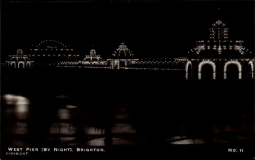 Ak Brighton East Sussex England, West Pier bei Nacht,  beleuchtet, Copyright