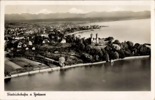 Ak Friedrichshafen am Bodensee, Luftaufnahme von  Bodensee, Wasser, Bäume, Berge im Hintergrund