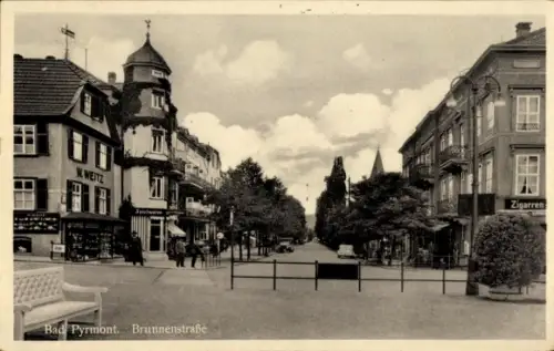Ak Bad Pyrmont in Niedersachsen,  Brunnenstraße, Geschäfte, Bäume, Menschen
