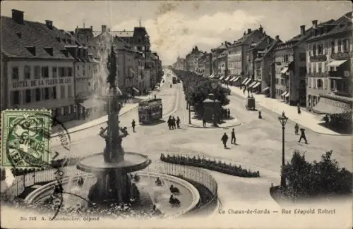 Ak La Chaux de Fonds Kanton Neuenburg, Rue Leopold Robert, Brunnen, Straßenbahn