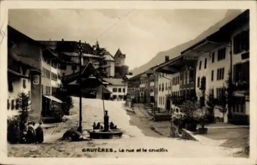 Ak Gruyères Kanton Freiburg Schweiz, GRUYÈRES, Straße, Kreuz, Brunnen, Häuser