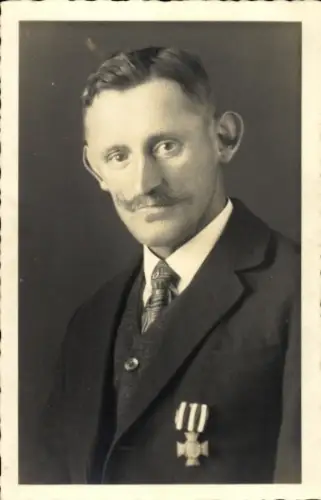 Foto Ak Mann in schwarzem Anzug, Abzeichen