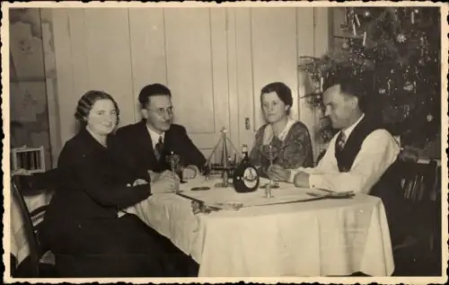 Foto Ak Weihnachten 1937, zwei Männer und zwei Frauen am Tisch, Flasche, Tannenbaum