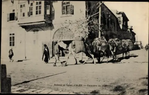 Ak Aleppo Syrien, Karawane von Kamelen, Straße in  Menschen, Gebäude