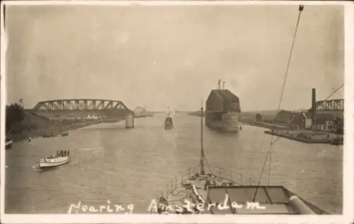 Ak Amsterdam Nordholland Niederlande, Schiff auf Wasserweg, Brücke, Gebäude, Text: Nearing Amster
