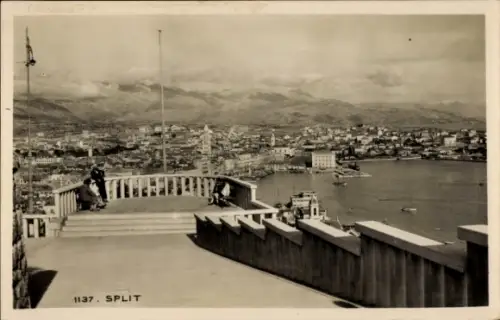 Ak Split Kroatien, Stadtansicht von  Küstenlinie, Berge im Hintergrund, Menschen auf der Treppe