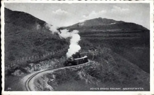 Ak Aberystwyth Wales, Dampflok, kurvenreiche Bahnstrecke, Berglandschaft, Dampfwolken