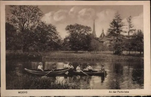 Ak Moers am Niederrhein, Sechs Personen in Booten, Parkwiese, Bäume, Kirche im Hintergrund