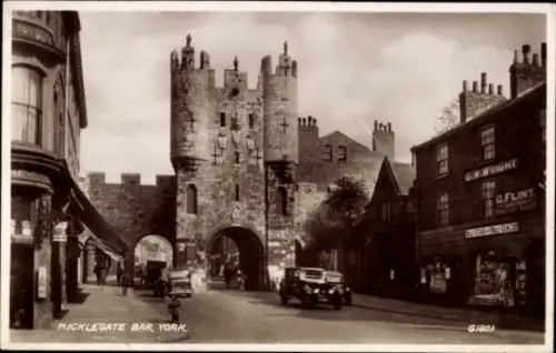 Ak York Yorkshire England, Micklegate Bar,   Stadtmauer, Autos, Fahrräder, Geschäfte