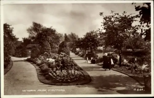 Ak Stafford West Midlands England, Victoria Park,  Parklandschaft, Spaziergänger, Bäume, Blumenbe