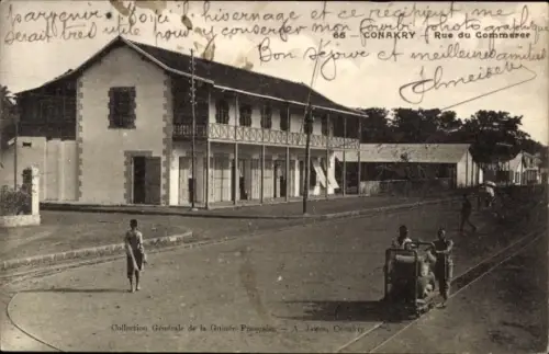 Ak Conakry Guinea, Straße mit Häusern, Menschen, Karren, '66-CONAKRY Rue du Commerce'
