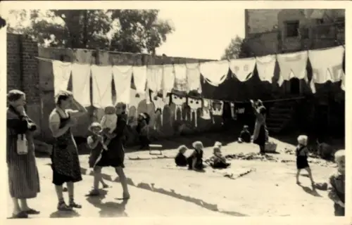 Foto Ak Warszawa Warschau Polen, Hinterhof, aufgehängte Wäsche, Frauen, spielende Kinder