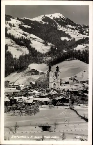 Ak Hopfgarten im Brixental in Tirol, Schneebedeckte Berge, Kirche mit zwei Türmen, kleine Häuser,