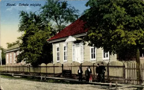 Ak Kowel Ukraine,  Schule, Bäume, Zaun, Menschen