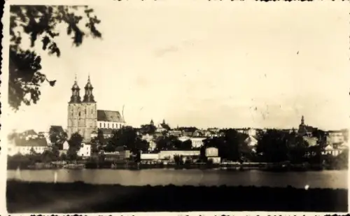Ak Gniezno Gnesen Posen, Stadtansicht, Fluss, Bäume, Kirche mit zwei Türmen